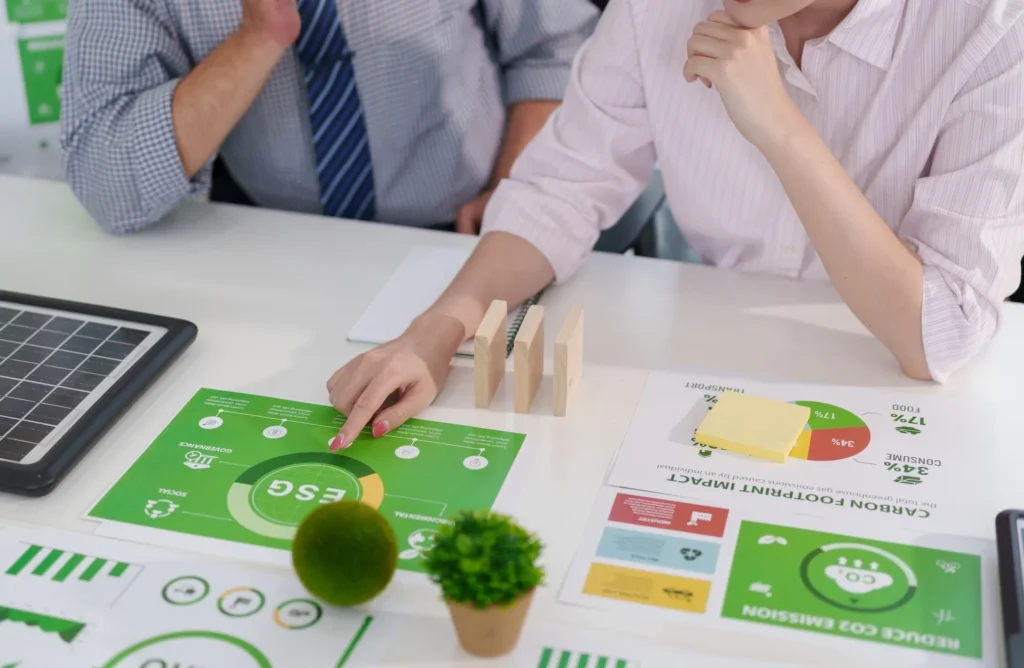 Due professionisti analizzano dati ESG e reporting di sostenibilità su schema con pilastri Environmental, Social e Governance