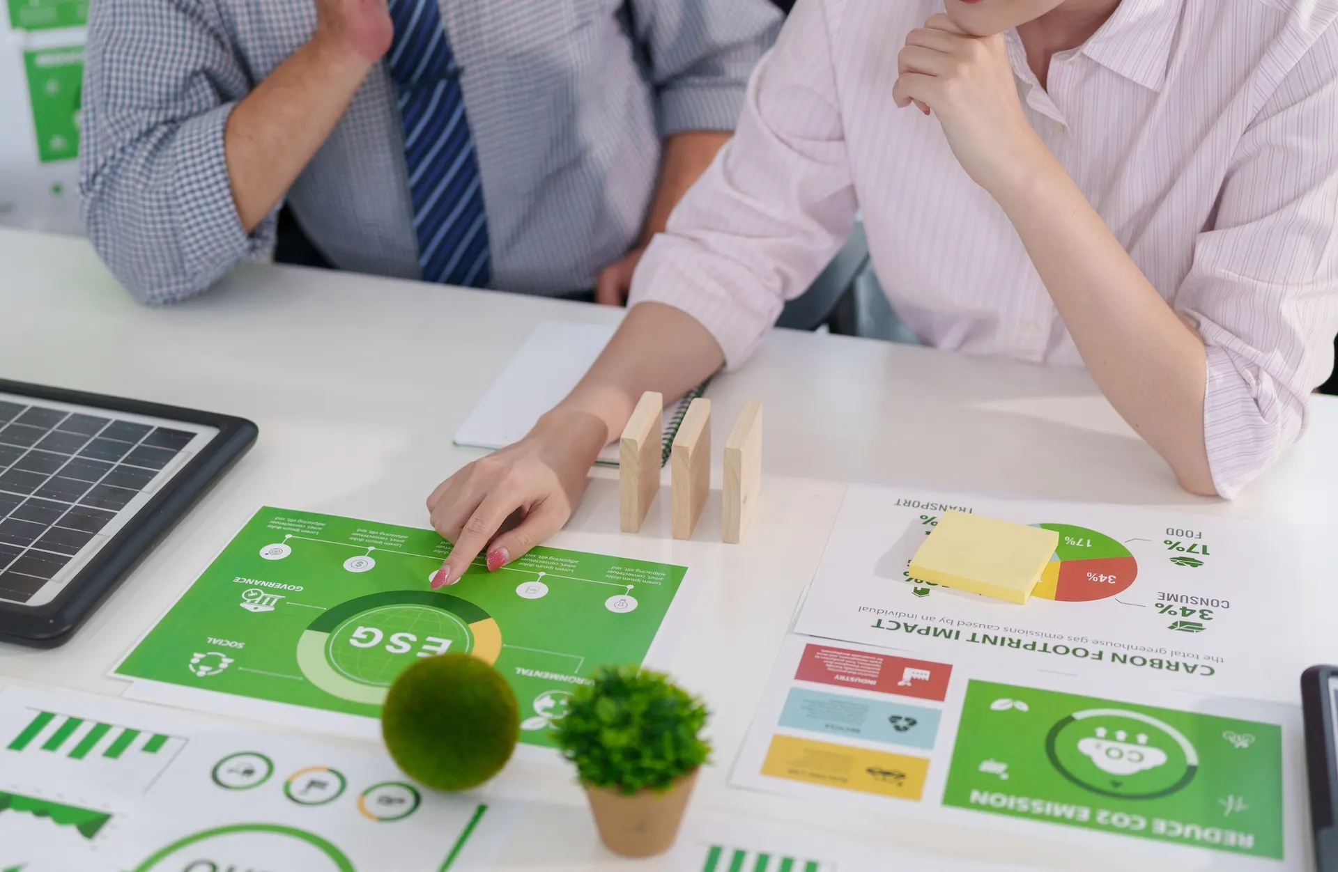 Due professionisti analizzano dati ESG e reporting di sostenibilità su schema con pilastri Environmental, Social e Governance