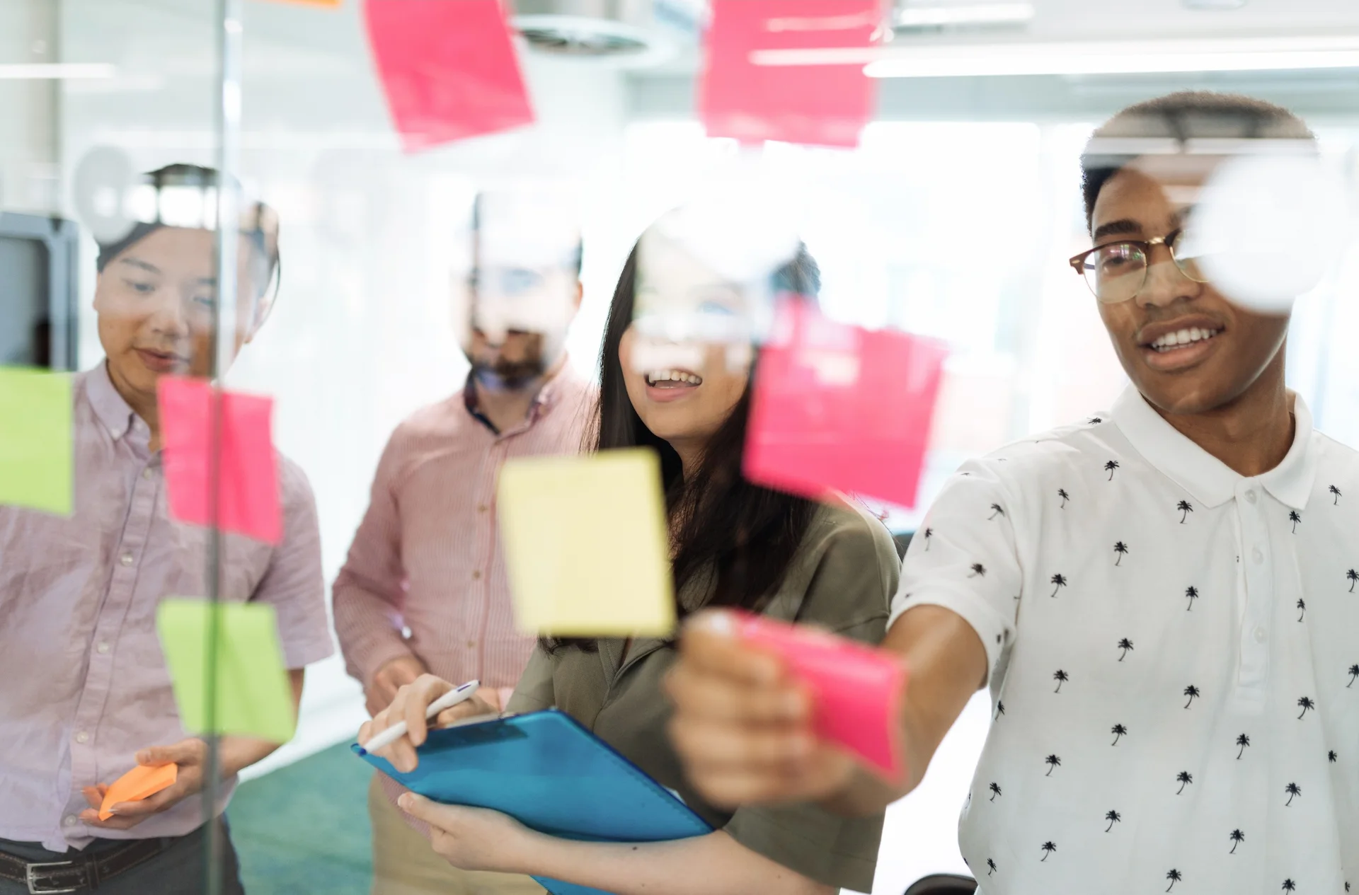 Team aziendale collabora con post-it su una parete di vetro durante un percorso di formazione finanziata sulle competenze ESG